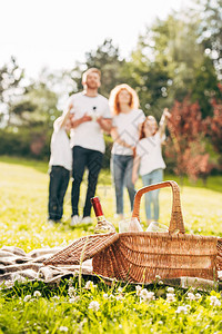 围观野餐篮子和家庭站在公图片
