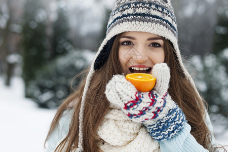 妇女在冬季吃橙子时图片