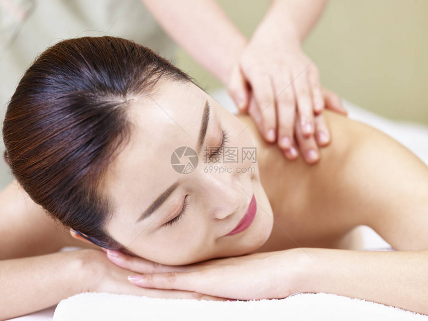 近距离的面孔一个美丽的年轻亚洲女人躺在前面的床上在温泉图片
