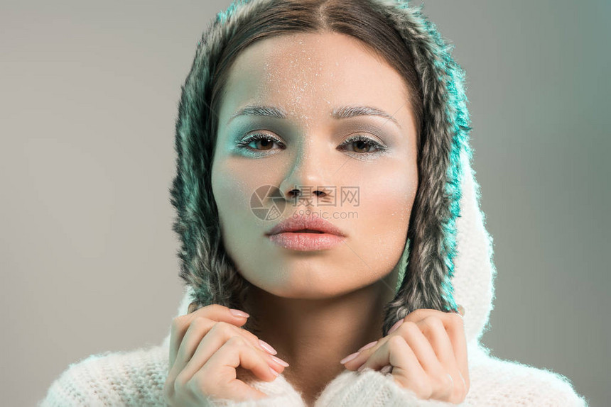 一名年轻有魅力脸霜冻的女士身穿毛衣和头图片