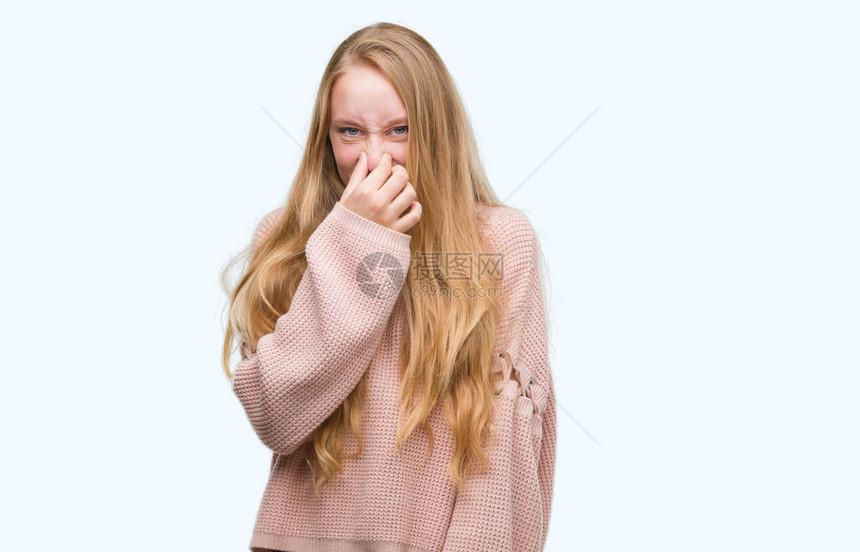 穿粉红色毛衣的金发少女闻到臭味恶心难以忍受的气味图片