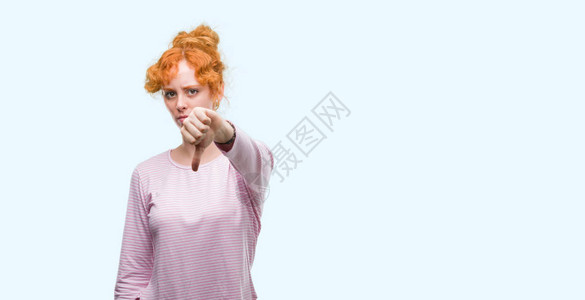 年轻红发女人看着不开心和愤怒的情绪图片