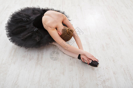 年轻芭蕾舞者在黑色礼服古典舞蹈演播室复制空间表演前练过歌舞练习图片