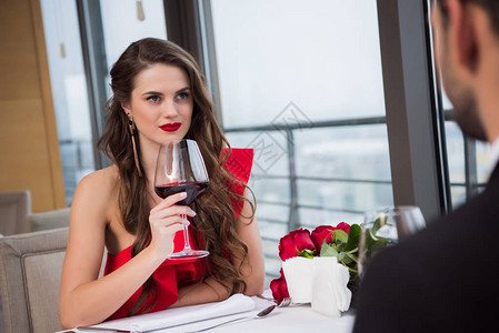 情人节那天在餐厅约会时喝着红酒的女背景图片