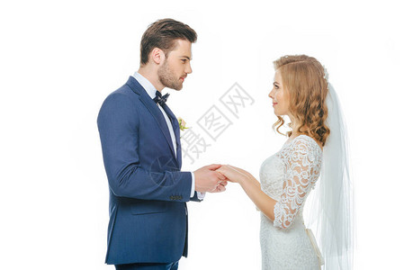 美的结婚情侣相牵手看着彼此在白图片