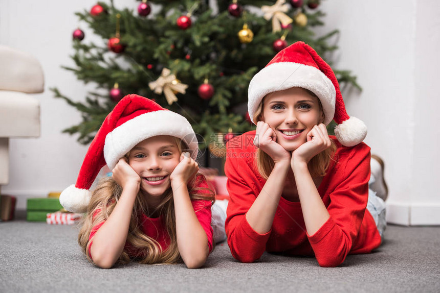 戴着圣诞树的圣诞礼帽的母亲和图片
