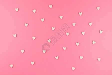 情人节图案背景平铺的粉红色心形糖果的顶视图散落在粉红色背景爱图片