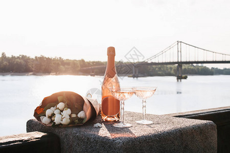 两杯香槟两杯酒和美丽的花束在日图片