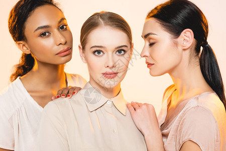 三位美丽的多文化女美容在米背景图片