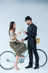 微笑的多元文化夫妇的侧面视图与复古自行车碰杯香图片