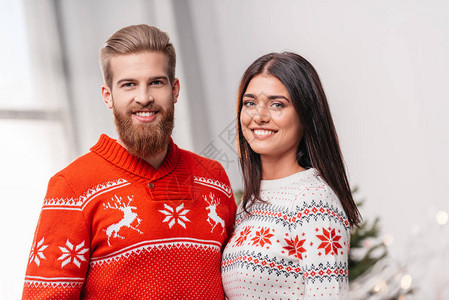穿着温暖编织毛衣的年轻美女夫妇在室内图片