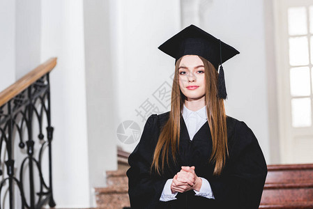身着毕业帽子的有吸引力的年轻女子看着相机图片