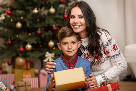 快乐的母亲和儿子带着圣诞节礼物并一起图片