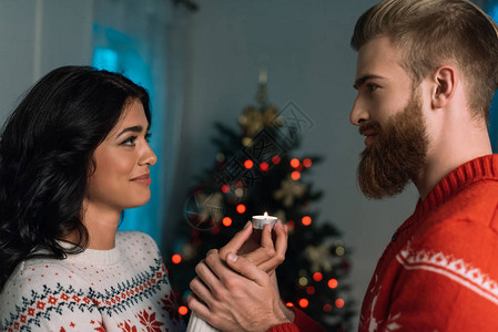 快乐的一对情侣和蜡烛在圣诞图片