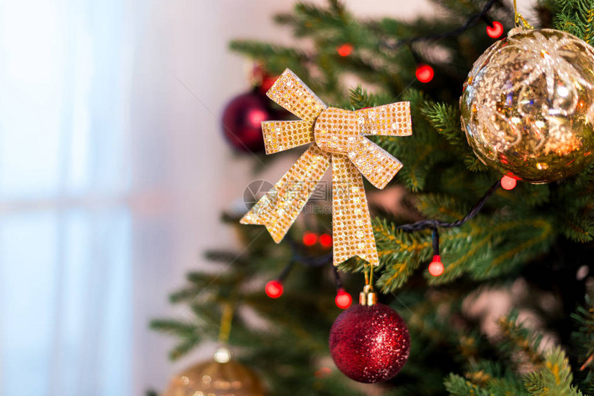 挂在圣诞枝上的美丽装饰蝴蝶结图片