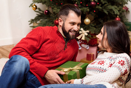快乐的一对年轻幸福的情侣带着圣诞节礼物图片