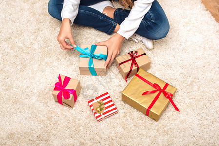 在圣诞节前夕坐在地毯上的礼物盒上图片