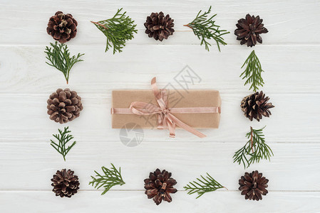 圣诞礼物和美丽的常绿针叶树枝与松果的顶视图图片