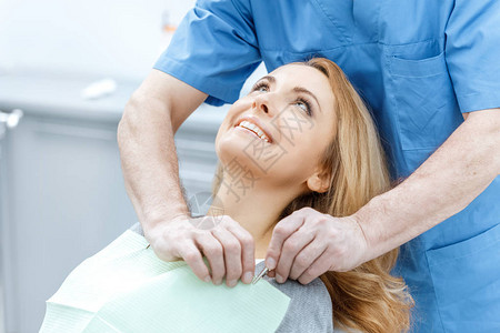 与牙医生在牙科诊所的美丽微笑图片