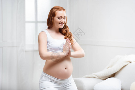 笑着迷人的红头发孕妇在家里做瑜伽时有鼻涕泥巴图片