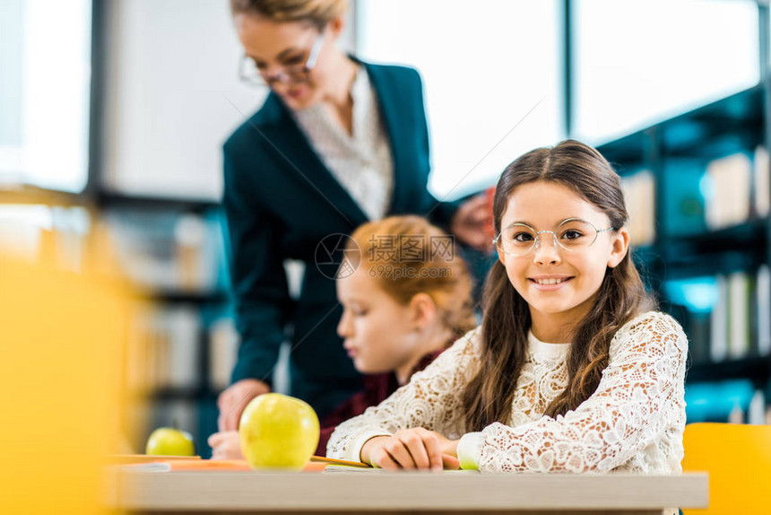 美丽的小学生在与图书馆的同学和老师一起学习时图片