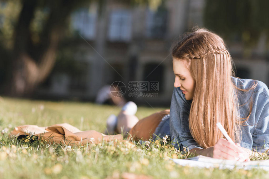 微笑着的年轻女子在公园草图片