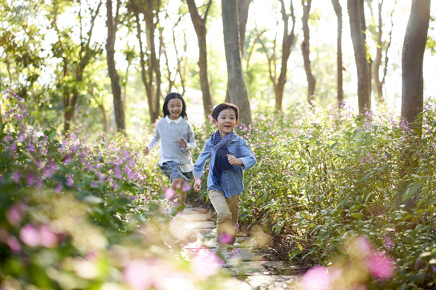 两个小亚裔男女儿童在公园的花图片