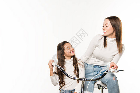 母亲和女儿带着自行车微笑地着看对方彼此图片