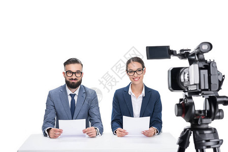 两个微笑着的新闻播报员报纸坐在镜头前在背景图片
