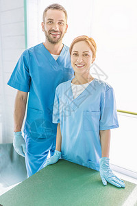 两名身着制服的笑着微笑的兽医站在兽医诊所看摄影图片