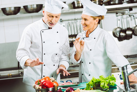 穿制服和戴帽子的男女主厨在餐厅厨房图片
