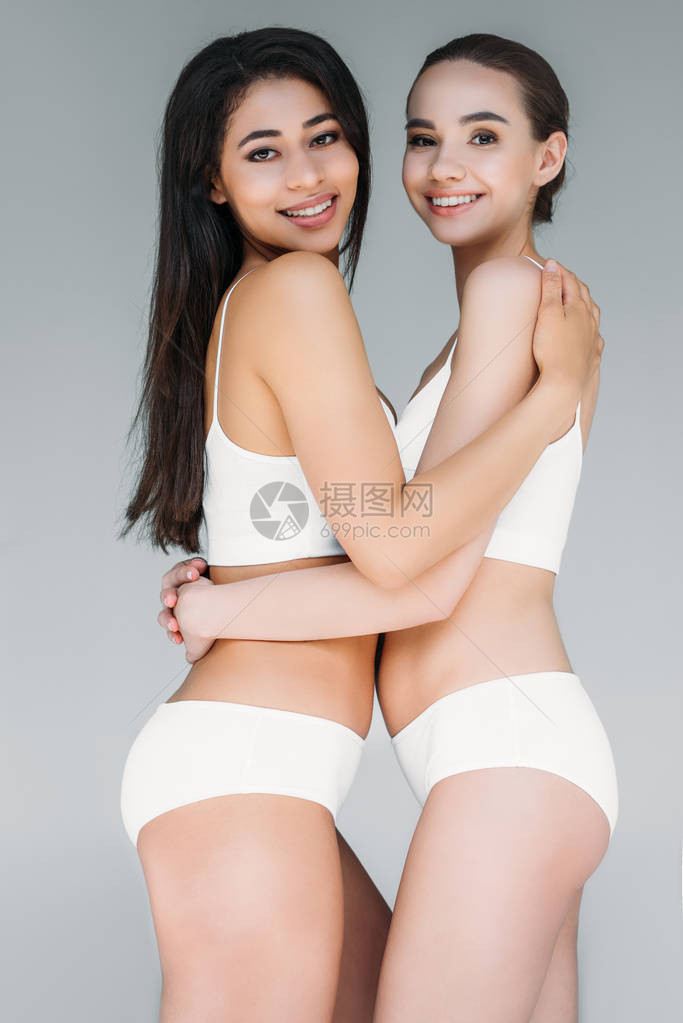充满微笑的多文化妇女相互拥抱在灰色图片