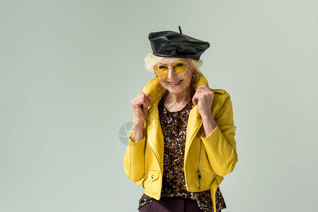 穿着黄色夹克和皮革贝雷帽的时髦高级女士图片