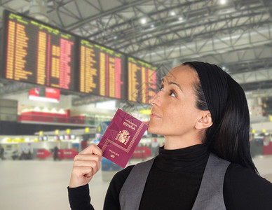 带着护照在机场看面板的漂亮女人图片