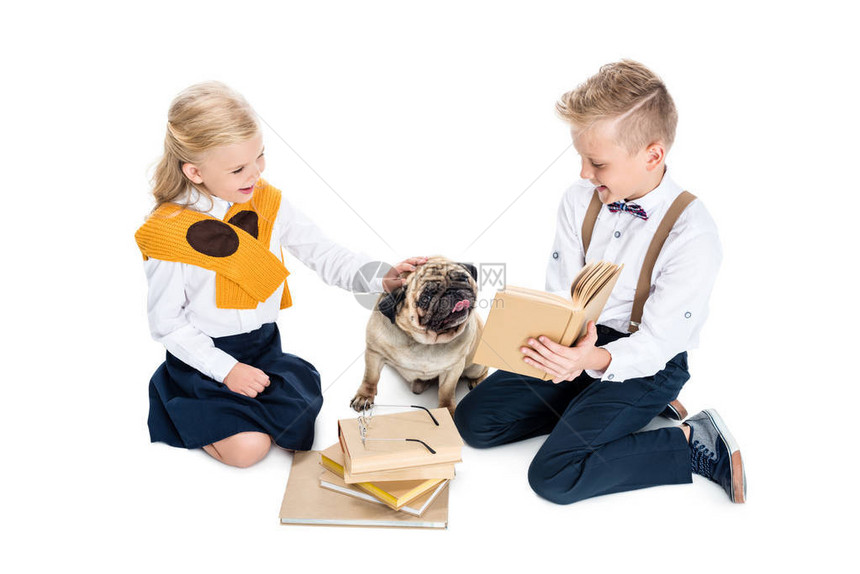 可爱的小孩在看书和玩狗却被图片