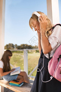 在同学习时用耳机听音乐的少女图片
