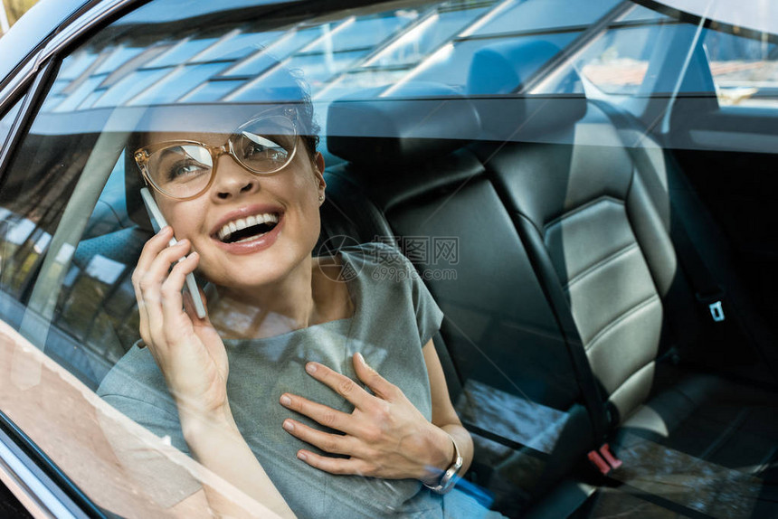戴着眼镜的快乐女人在汽车里谈论智图片