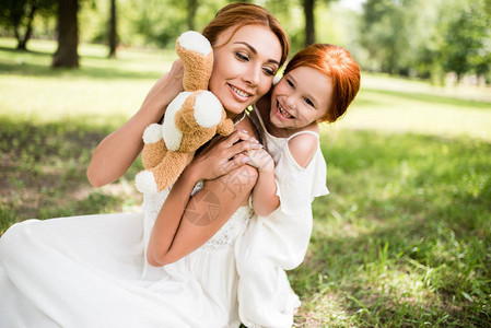 美丽的快乐母亲和女儿与泰迪熊图片