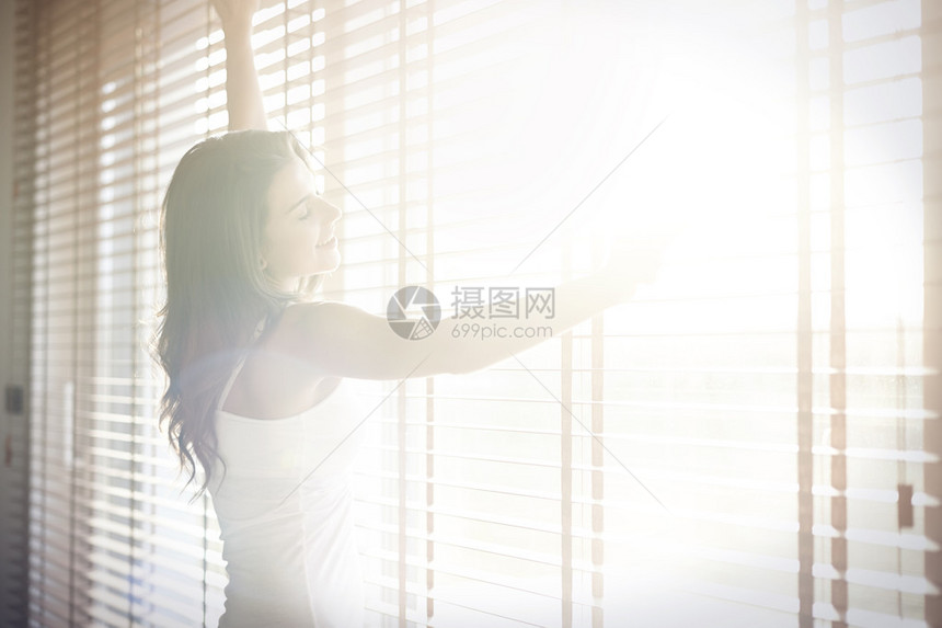 阳光灿烂的房间的窗户旁边的女人阳光明媚的图片