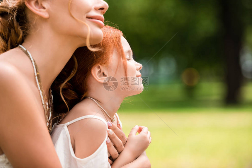 美丽的快乐母亲和女儿在公园抱图片