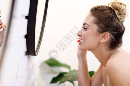 年轻女子在浴室刷牙的照片图片