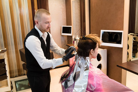 专业男美发师在现代沙龙选择染发剂颜色图片