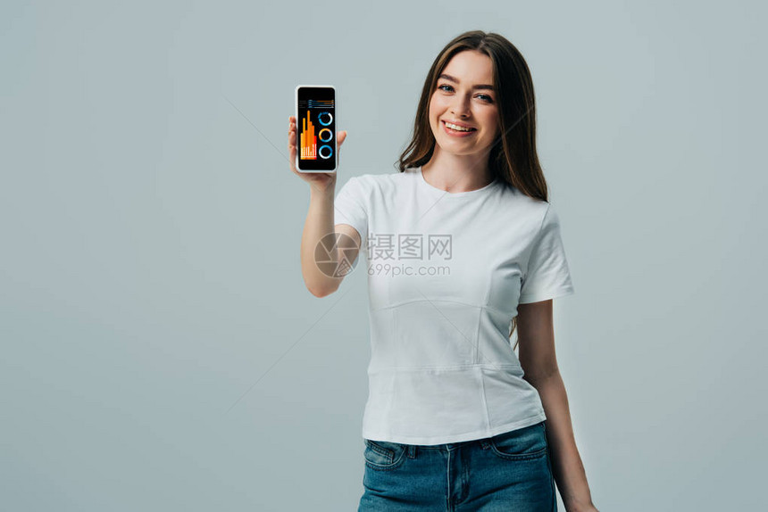 穿着白色T恤衫的快乐美丽女孩显示智能手机财务应用程序图片