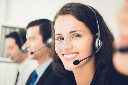 在呼叫中心作为操作员或客户服务人员工作的美丽微笑图片