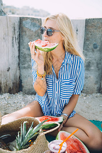 夏日野餐时吃西瓜的年轻美女肖像图片