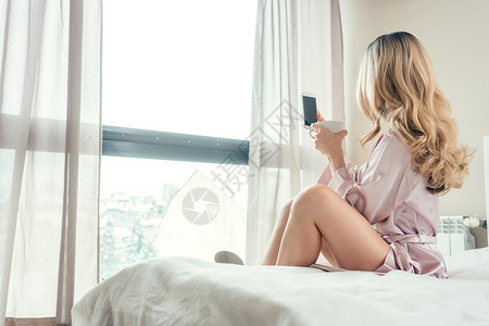 女人早上在卧室里用手机自拍图片