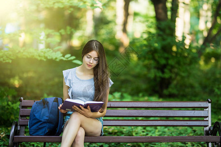 女学生坐在长凳上看书图片