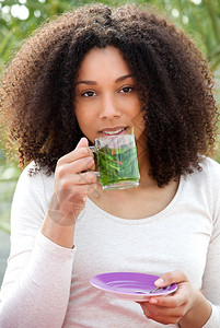 一个在户外喝茶的年轻美女图片