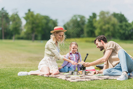 在野餐时一个孩子坐在一格子上坐在一图片