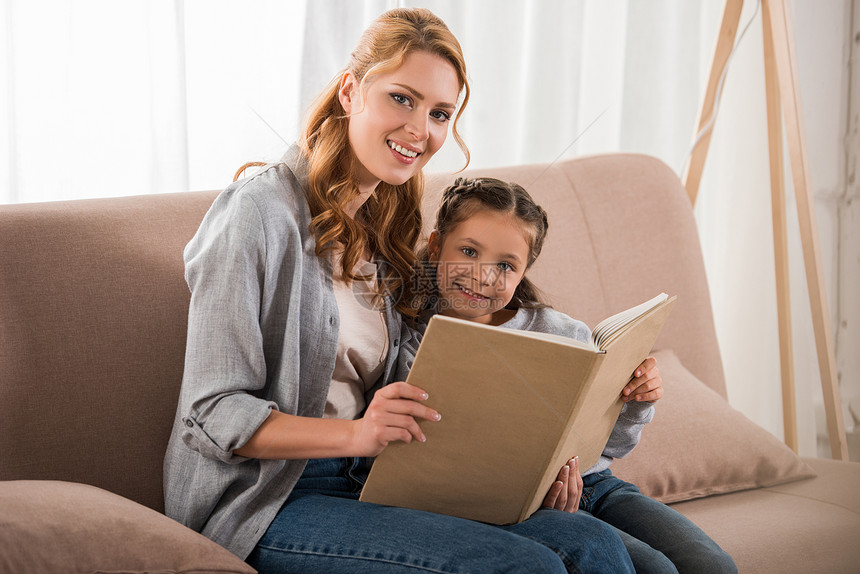 幸福的母亲和女儿一起在家里阅读书在照图片